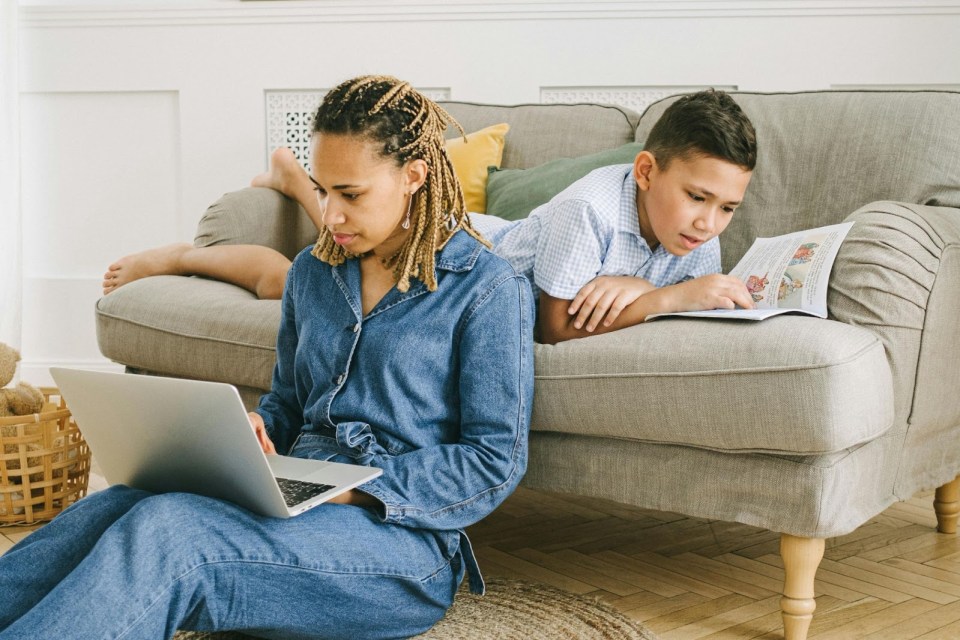 Mom and son are on their laptops for an article about 10 digital tools every busy parent needs in 2025