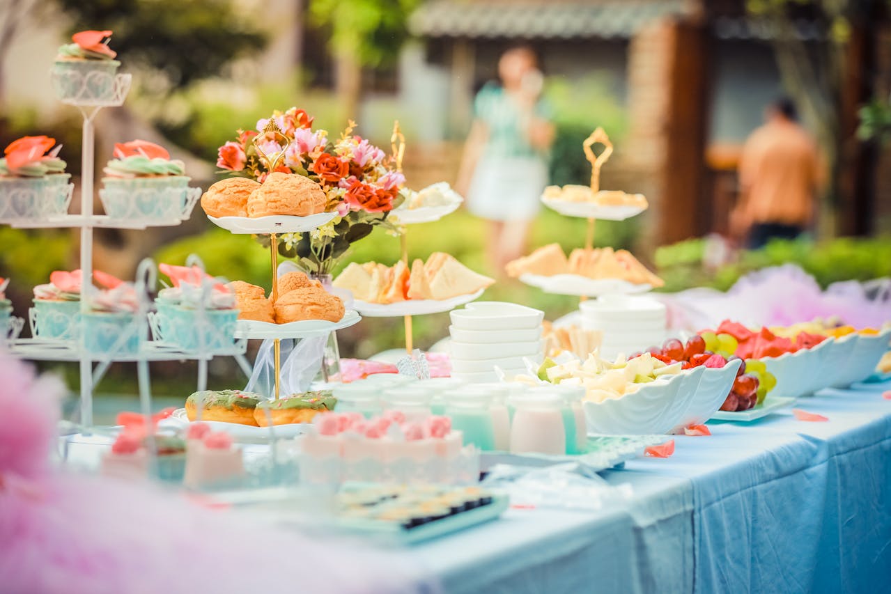 A tablescape of food for a baby shower for an article about how to plan a baby shower that supports new parents in their journey.