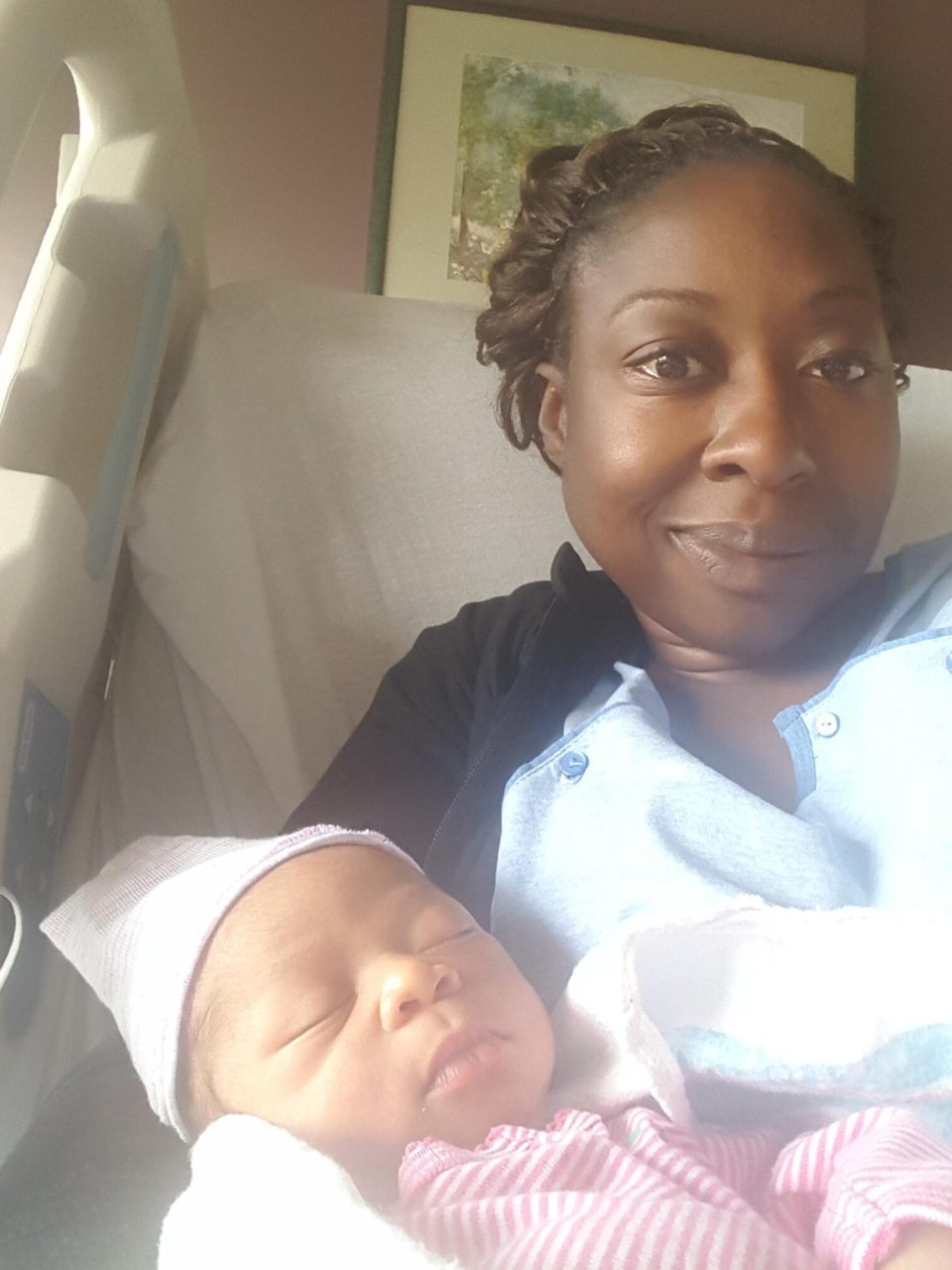 Jana holding her newborn in a hospital bed, glowing with joy as a new single mom by choice for an article about black, single, and proud: why more black women are choosing motherhood on their own terms.