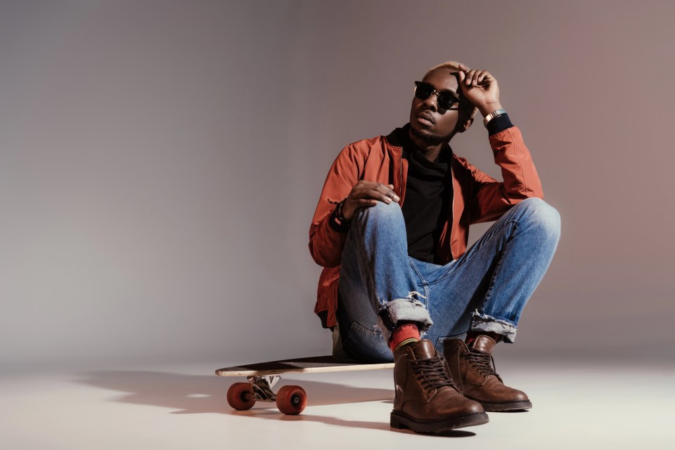 A parent’s guide to understanding the latest teen clothing trends and styles A fashionable african american male teen sitting on a skateboard for an article about a parent’s guide to understanding the latest teen clothing trends and styles