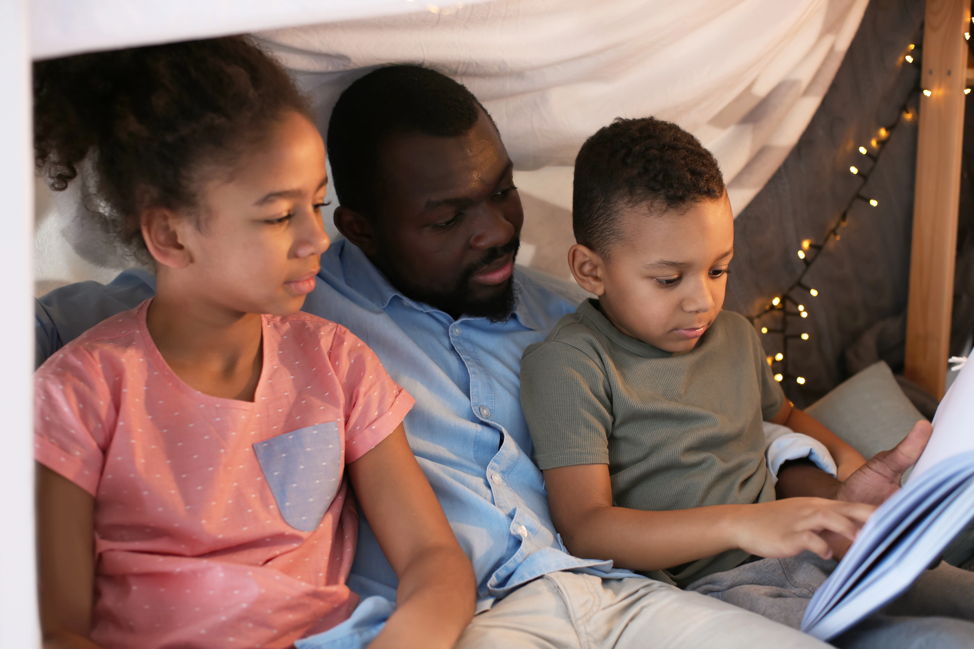 A dad reads his children bedtime stories to make bedtime fun.
