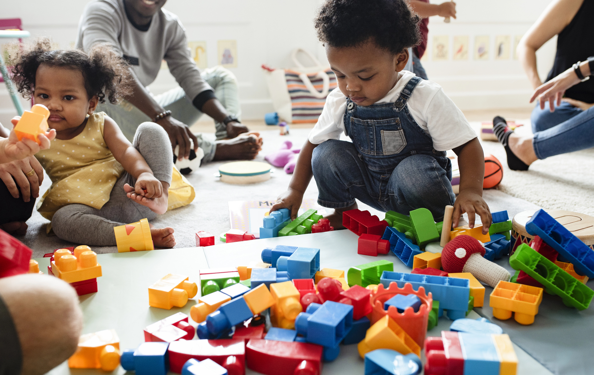 10 things to look for when choosing an after school care program African american children participating in an after school care program, playing with building blocks in a nurturing, supervised environment focused on development and learning.