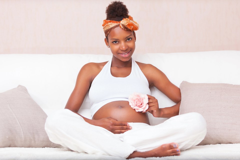 Teen pregnancy in the african american community: overcoming the odds An african american teen showing her belly for an article about teen pregnancy.
