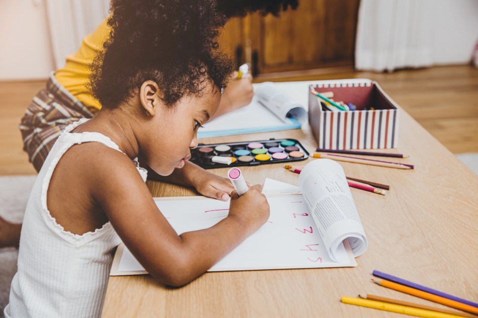 Why smart play matters: the science behind toys and learning An african american child colors with markers, pencils and watercolors for an article about why smart play matters: the science behind toys and learning