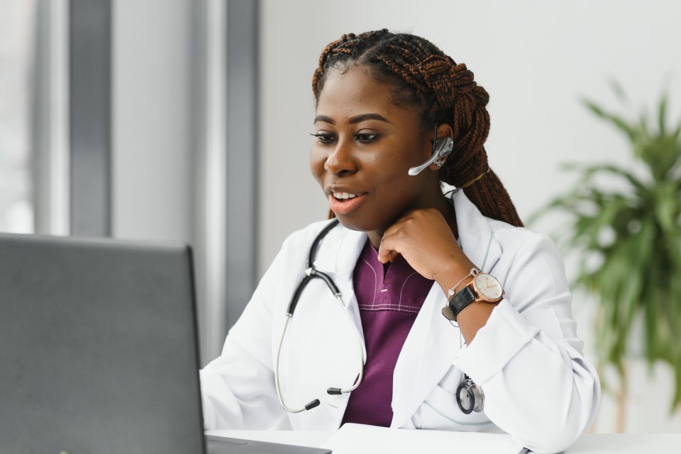 Navigating health for your family in the online era An african american female doctor is on her computer during the online era and navigating health for your family.