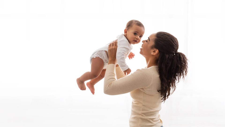 Self-care for moms: how to recharge while raising a happy and healthy family An african american mom holds her baby up high for an article on self-care for moms: how to recharge while raising a happy and healthy family
