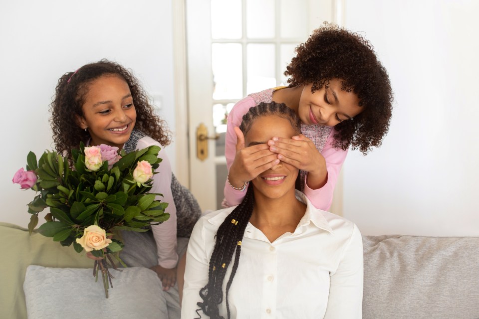 Daughters surprise their mom with roses for an article about mother's day roses: the complete guide to choosing perfect blooms