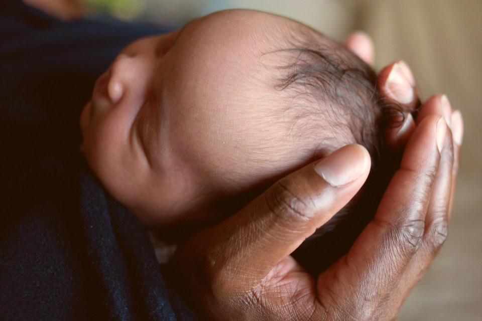 An african american newborn baby cradled in his mother's hands for an article about immune health