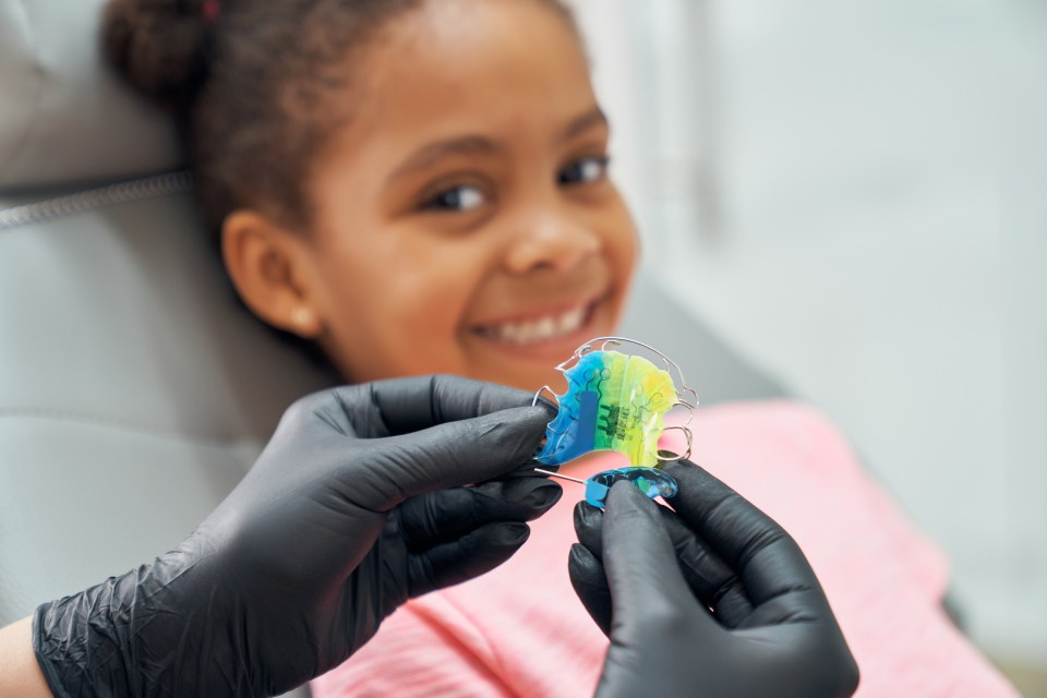 Familiar faces building a trusting relationship between children and their orthodontist on successful black parenting magazine