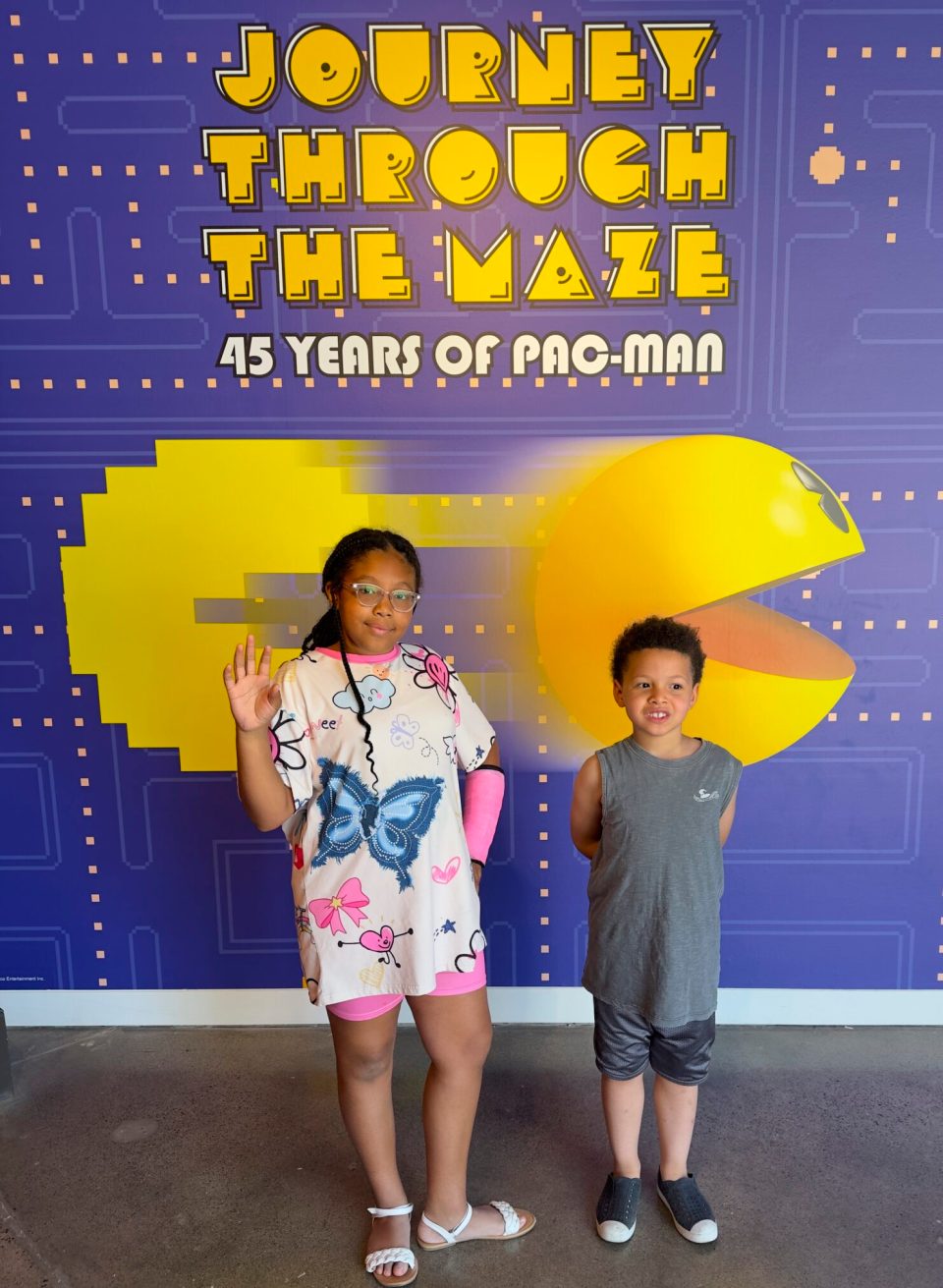 The pac-man exhibit in irvine, california, with a young black girl with braids and a young boy.