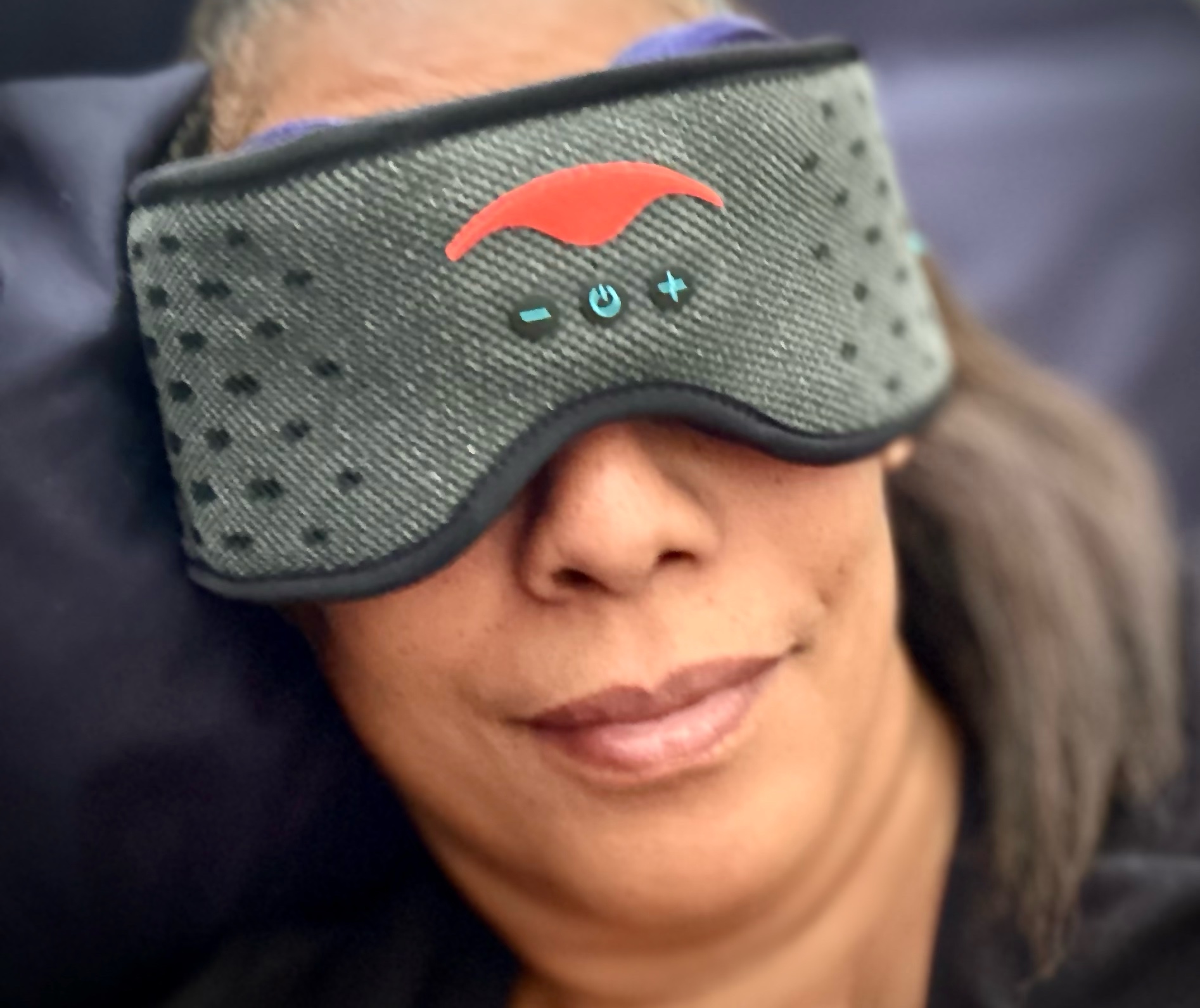 Shhh... Mommy's sleeping: how to outsleep the snorer and outsmart the night Woman wearing the manta sound mask with bluetooth controls, relaxing while using the sleep aid to block snoring and play calming affirmations.