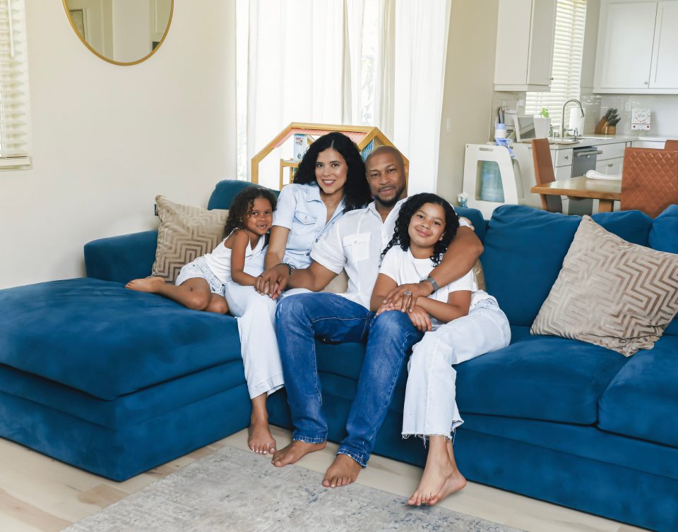 Dad jokes on deck: finesse mitchell’s best role yet Finesse mitchell and his wife adris debarge sit on a blue sectional with their daughters, eva kristian on adris’s lap and elle kate leaning against finesse’s leg, as a family portrait in their living room.