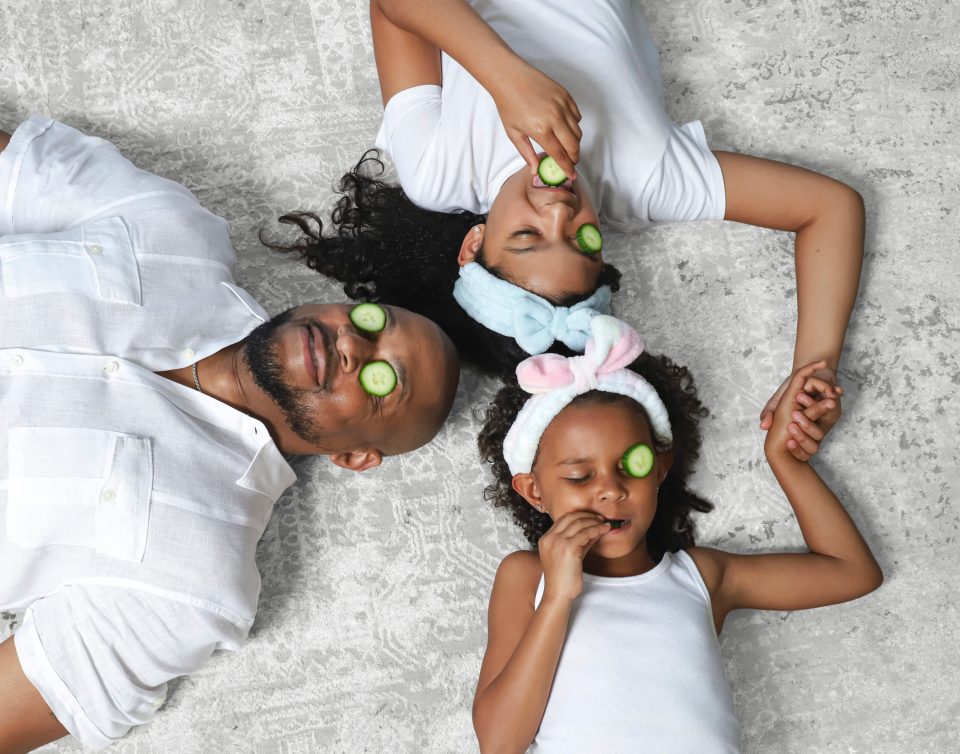 Dad jokes on deck: finesse mitchell’s best role yet Finesse mitchell lies on a light gray rug holding hands with his daughters, elle kate and eva kristian, each wearing a cucumber slice over one eye for a playful at-home spa moment.