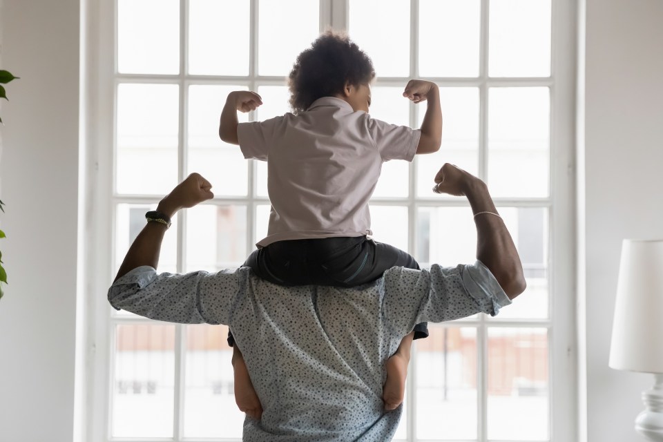 Protecting a child's life: a comprehensive guide through all stages of growth African american dad protecting a child's life by showing him and his son's strength in their arms in front of a window.