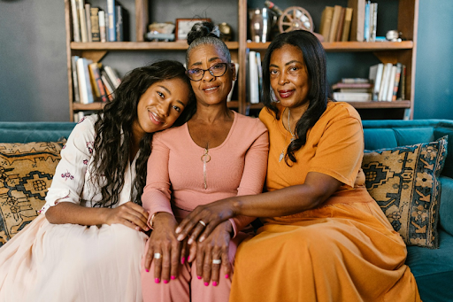 Three generations of stylish black women sitting together, symbolizing mom style through every chapter of motherhood.